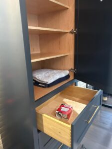 Custom cabinets CT detail view showing interior shelves and a soft-close drawer with wood finish and brass handle, part of a Mobile closet installation in Greenwich.