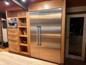 Custom cabinets CT featuring built-in stainless steel appliances, open shelving, and wood cabinetry in a modern Greenwich kitchen renovation by Mobile.