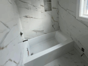 Renovated bathroom with marble imitation tiles and built-in niche