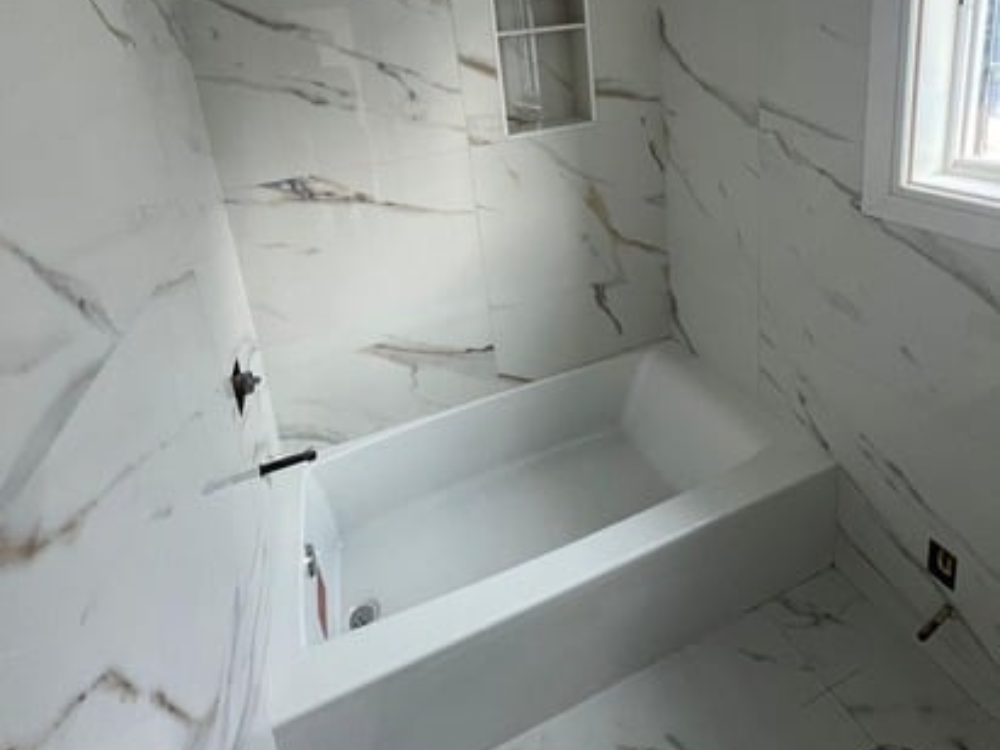 Renovated bathroom with marble imitation tiles and built-in niche