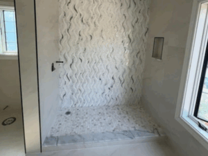 Bathroom renovation with wave-patterned tiles and modern shower design.