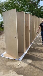 Door painting preparation showing unpainted wooden doors before spraying.