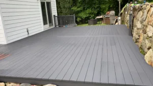 Deck refinishing and exterior painting showing wide view of gray finished deck.