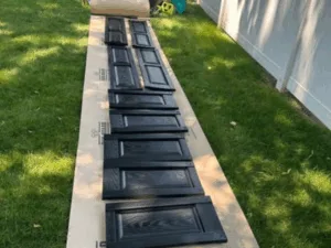 Close-up of freshly painted kitchen cabinet doors drying outdoors.