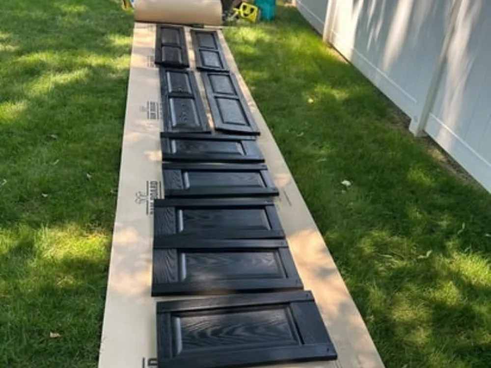 Close-up of freshly painted kitchen cabinet doors drying outdoors.