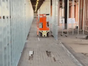 Metal stud framing installation along a corridor under construction.