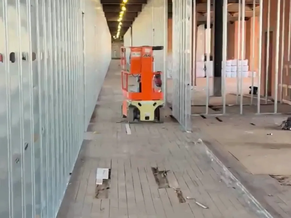 Metal stud framing installation along a corridor under construction.