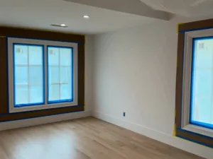 Interior finish and trim preparation highlighting recessed lighting, detailed trim masking, and smooth wall surfaces.