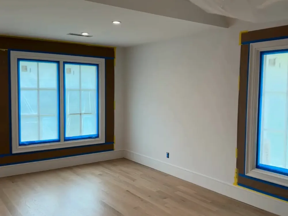 Interior finish and trim preparation highlighting recessed lighting, detailed trim masking, and smooth wall surfaces.